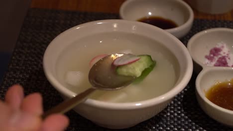Dongchimi-Korean-Rettich-Wasser-Kimchi,-Zeigt-Auf-Löffel-Nahaufnahme-Im-Restaurant
