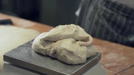 closeup,-baker's-hands-weigh-dough-on-rye-bread