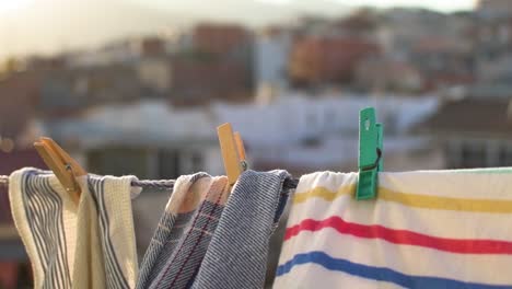 Clothes-hanging-by-clothespins-on-a-sunset-with-the-city-in-the-background-blurred