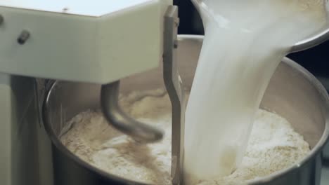 the-baker-pours-the-sourdough-into-a-machine-that-mixes-the-bread-dough