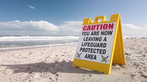 Señal-De-Precaución-En-La-Playa,-Ahora-Está-Saliendo-De-Un-área-Protegida-Por-Salvavidas