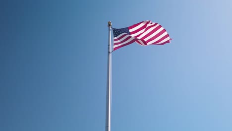 Amerikanische-Flagge-Weht-Stolz-Mit-Klarem-Blauem-Himmelshintergrund,-Zeitlupe