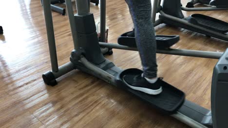 Close-up-foot-working-out-on-the-stepper-exercise-machine-at-the-gym,-stepper-machine-on-the-wooden-floor