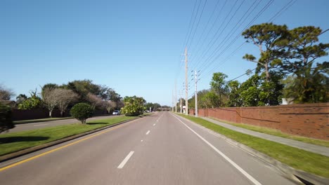 Driving-on-road-in-residential-Florida-neighborhood-on-sunny-day,-POV