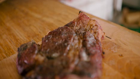 Zoom-in-a-close-up-view-of-hot-juicy-and-smoky-marinated-steak-on-a-wooden-table
