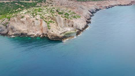 Aerial-panning-shot-of-rugged-coast-and-protected-lagoon-near-Island-of-Crete