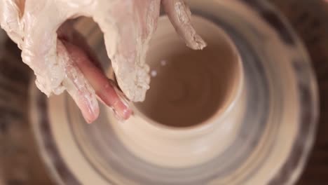 Man potterist making bowl on a potters wheel from clay in a ceramic studio  close up. Traditional pottery hobby art. Stock Video Footage by ©Kallihora  #497617694