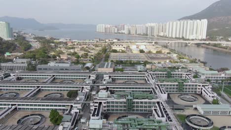 Shatin-Sewage-Treatment-facility,-with-Hong-Kong-residential-buildings-in-the-horizon,-Aerial-view