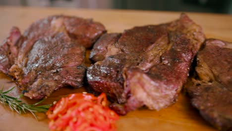 Delightful-view-of-freshly-grilled-steak-out-from-oven-to-wooden-board