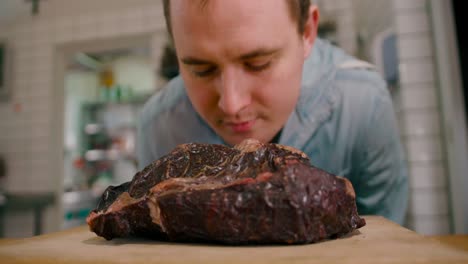 Close-up-footage-of-a-man-smelling-the-freshly-grilled-steak-in-the-country-house