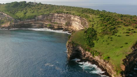 Aerial-view-Moving-forward-shot,-green-grass-and-trees-on-the-top-of-the-cliff-of-Tanjung-Ringgit