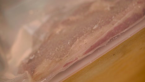 Close-up-view-of-the-vacuum-packer-shrink-wraps-the-raw-meat-in-preparation-for-sous-vide-cooking