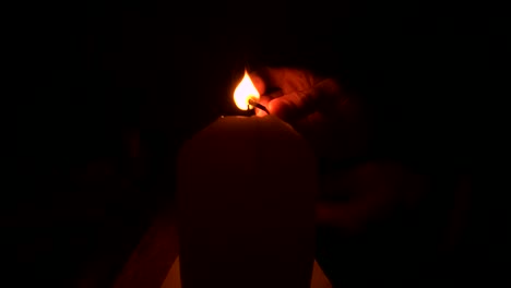Lighting-a-candle-with-a-match-in-the-dark