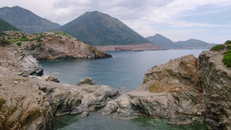 Aerial-pull-out-over-protected-lagoon-among-rugged-areas-of-the-Greek-Islands
