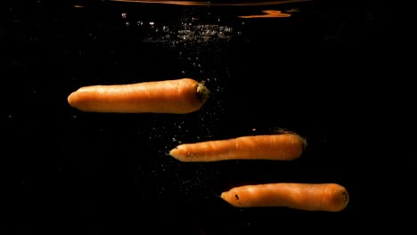 Tres-Zanahorias-Se-Vierten-En-El-Agua-Y-Se-Hunden-Lentamente-En-Las-Profundidades