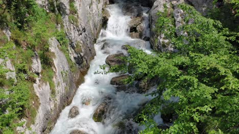 Aerial:-Backward-flight-away-from-Boka-Waterfall-flowing-through-rough-rocks-and-inaccessible-terrain