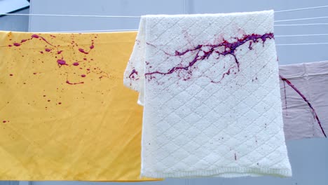 Slow-motion-shot-of-blood-splattering-on-a-towel-hanging-from-a-washing-line