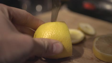 A-person-hands-cutting-a-yellow-lemon-on-a-cutting-board---Close-up-shot