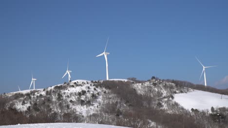 Parque-De-Turbinas-De-Energía-Eólica-En-La-Cima-Cubierta-De-Nieve-De-La-Montaña,-Corea-Del-Sur