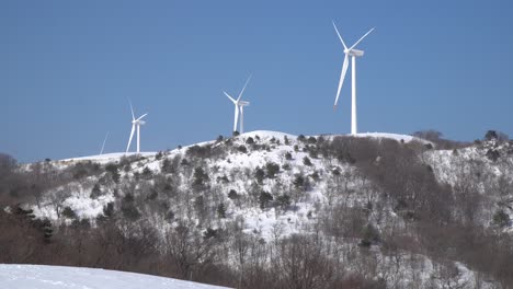 Las-Turbinas-Eólicas-Están-Funcionando-Para-Generar-Electricidad-En-La-Montaña-Cubierta-De-Nieve,-Portugal
