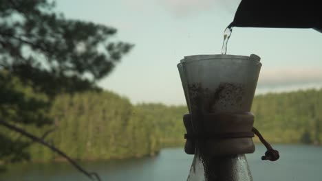 Pouring-boiling-water-into-paper-coffee-filter-in-Chemex-for-coffee-brewing-in-wilderness