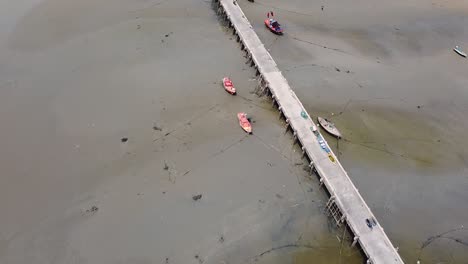 AERIAL,-Jetty-With-Beached-Water-Vessels-During-Low-Tide