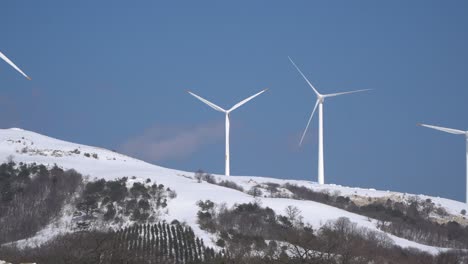 Wind-power-plants-are-seen-in-the-snow-covered-mountain,-Spain