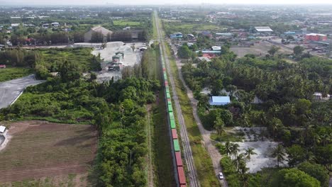 Wonderful-View-Of-A-Colorful-Train-Surrounded-By-Green-Trees---Aerial-Shot