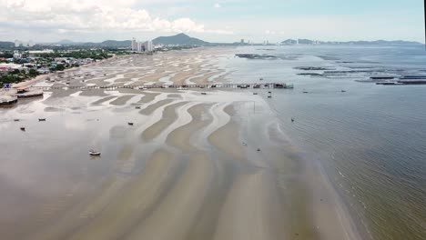 Boats-Washed-Ashore-On-The-Tidal-Flats-At-Bang-Saen-Beach-In-Chonburi,-Thailand---aerial-drone