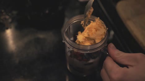 Putting-An-Ice-Cream-Inside-The-Blender-Jar-Full-Of-Ingredients