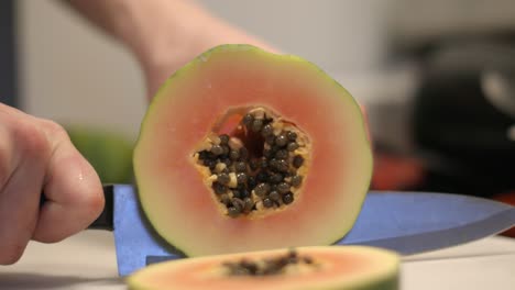 Narrow-focus-close-up:-Slicing-ripe-orange-papaya-fruit-with-seeds