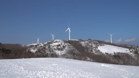 Parque-De-Energía-Eólica-En-Noruega,-Muchos-Molinos-De-Viento-Se-Están-Moviendo-En-La-Montaña-Cubierta-De-Nieve