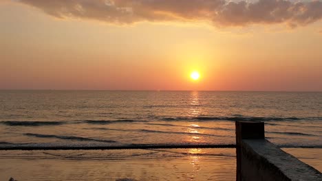 Atemberaubender-Sonnenuntergang-über-Dem-Strand-Mit-Ruhigen-Wellen,-Die-In-Den-Strand-Kommen