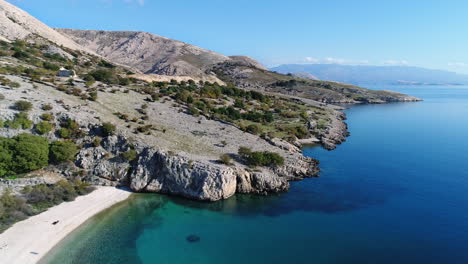 Aerial-of-a-lovely-beach-hidden-among-mountains-on-Croatia-coastline-near-Baska-village