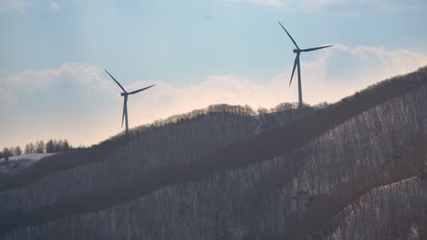 Silhouette-Von-Zwei-Windkraftanlagen-Auf-Dem-Berg-Bei-Sonnenuntergang