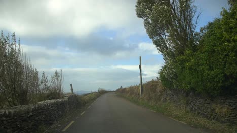 Driving-narrow-road-on-Slea-Head-Drive,-Dingle-Peninsula,-Kerry,-Ireland