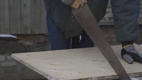 A-Worker-Holding-The-Handheld-Saw-And-Start-Cutting-The-Hardwood