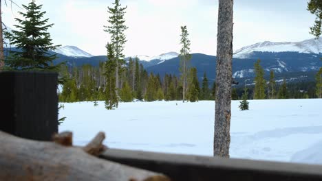 Stack-of-firewood---Views-of-mountain-range---Breckenridge,-Colorado---Winter-Scene-in-the-mountains---Panning-Right-against-wooden-railing