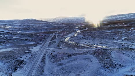 A-road-going-through-the-ice-covered-landscape-of-Iceland's-Phantom-Island---aerial