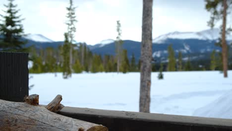 Stack-of-firewood---Views-of-mountain-range---Breckenridge,-Colorado---Winter-Scene-in-the-mountains---Zoom-In,-Close-Focus-on-Wooden-Log,-Blurry-background