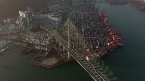 Hong-Kong-Container-terminal-and-port-at-Victoria-bay-with-full-view-of-Stonecutters-bridge,-storage-terminal-and-docked-Ships,-Aerial-footage