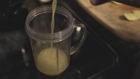 Pouring-Pineapple-Juice-To-A-Clear-Pitcher-For-Smoothie-Making---Closeup-Shot