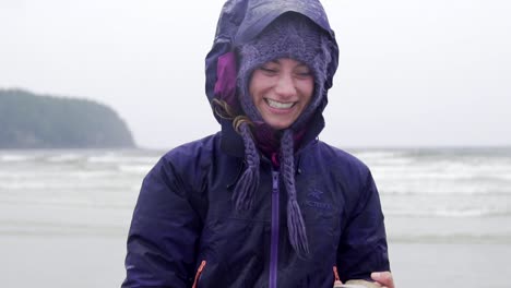 Happy-girl-running-and-enjoying-life-with-a-shelf-in-her-hand-witch-is-found-a-the-beach-on-a-drizzly-summer-day-in-Tofino-Slowmotion-shot