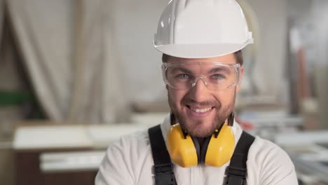 worker-in-hard-hat-looks-into-the-camera-and-smiles