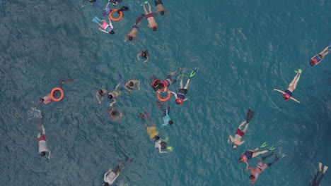 Grupo-De-Buceadores-Nadando-En-Un-Agua-Azul-En-Los-Bancos-De-Coral-Observando-La-Vida-Submarina-Con-Un-Barco-Turístico-A-La-Deriva-Cerca,-Nusa-Penida,-Bali,-Indonesia