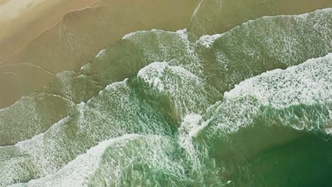 Aerial-rotating-view-of-stunning-sandy-beach-with-tropical-waves-rolling-into-the-shore
