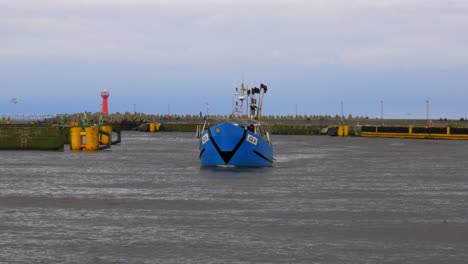Blue-Fishing-Boat-Enters-Harbor-in-Kolobrzeg,-Poland