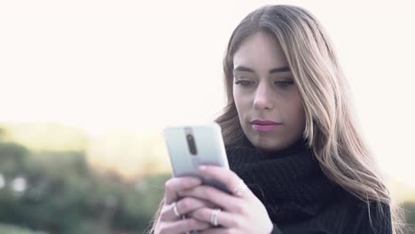 Slow-motion-video-close-up-of-a-young-blonde-caucasian-woman-face-texting-and-using-social-media-on-her-cell-phone