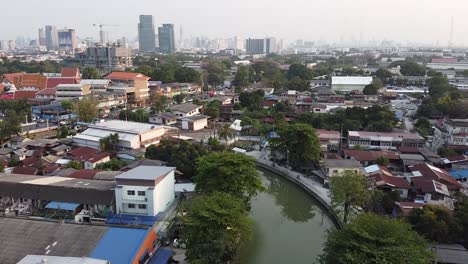 Stagnierendes-Kanalwasser-In-Der-Nähe-Der-Straße,-Umgeben-Von-üppig-Grünen-Bäumen-Und-Häusern-In-Einer-Ländlichen-Gegend-In-Thailand---Luftaufnahme