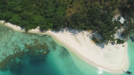 Beautiful-4K-UHD-aerial-drone-shot-of-tropical-Pacific-paradise-beaches-around-islands-in-Indonesia---Thailand---Asia-with-almost-no-waves,-clean,-clear-water,-a-coral-reef,-boat,-jungle-forest,-sand